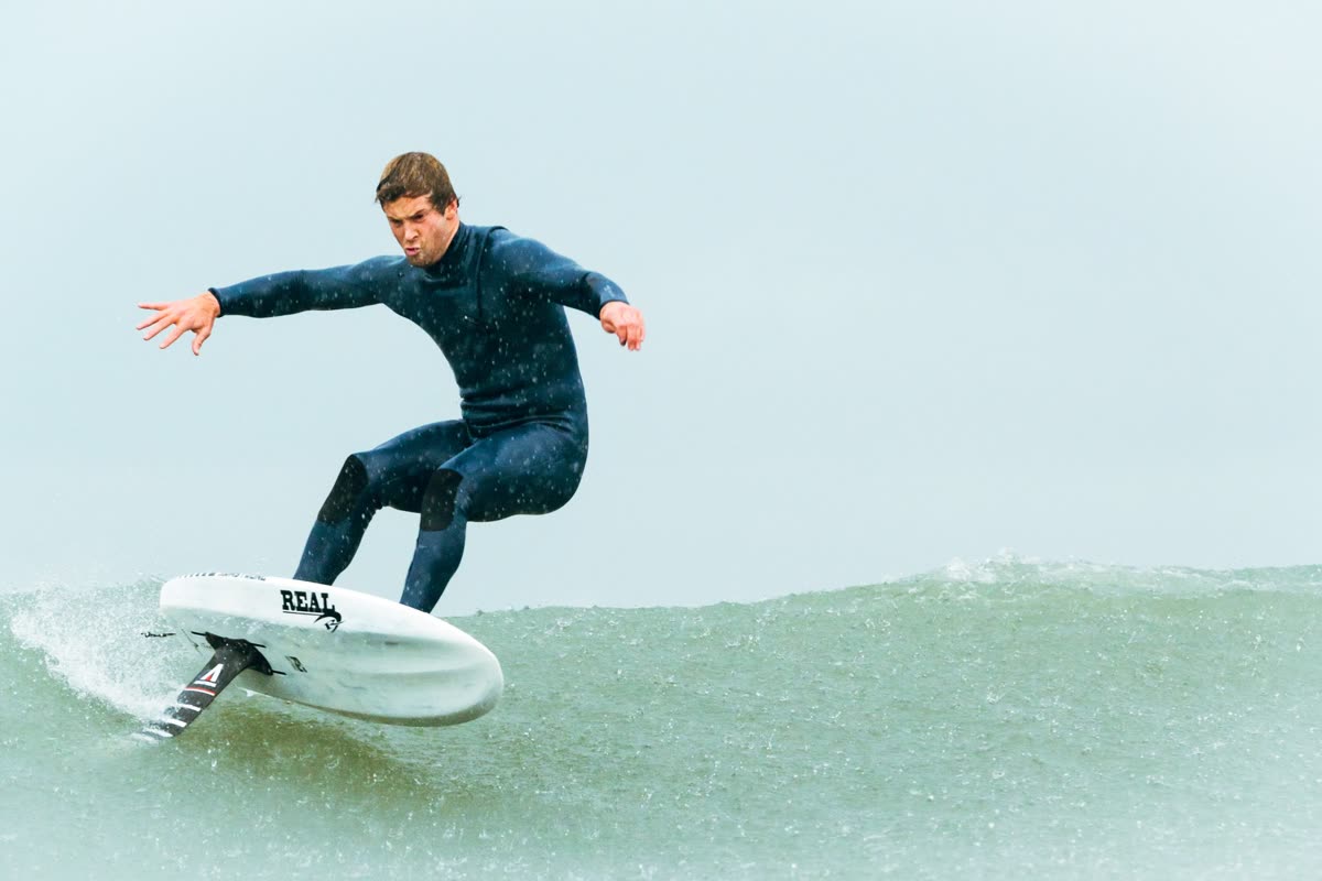 A rider carving on a prone surf foil in a wave, with no motor on the board.